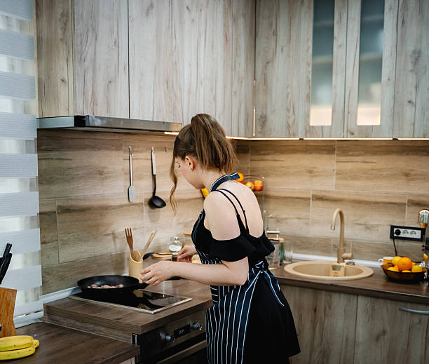 istock Young Woman Cooking on a Modern Kitchen Stove 2212427281