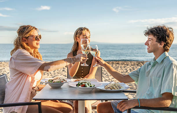 istock Friends toasting with white wine at beach restaurant 2212427288