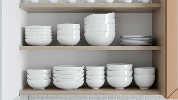 istock Distinctive white ceramic bowls and plates are systematically arranged on wooden shelves in a minimalist kitchen located in a contemporary home. Design highlights simplicity and elegance. 3d render 2212427547