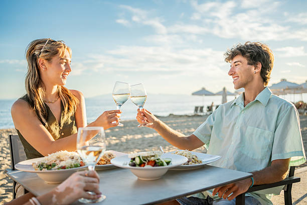 istock Friends toasting with white wine at beach restaurant 2212427645
