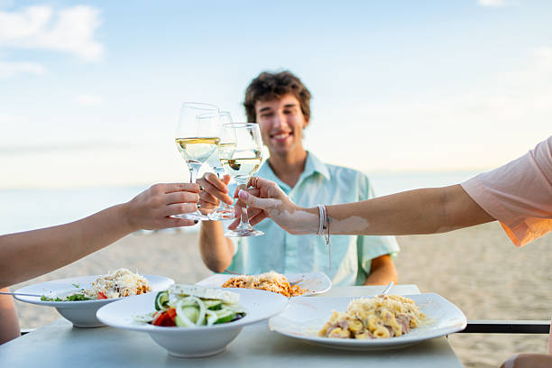 istock Friends toasting with white wine at beach restaurant 2212428086