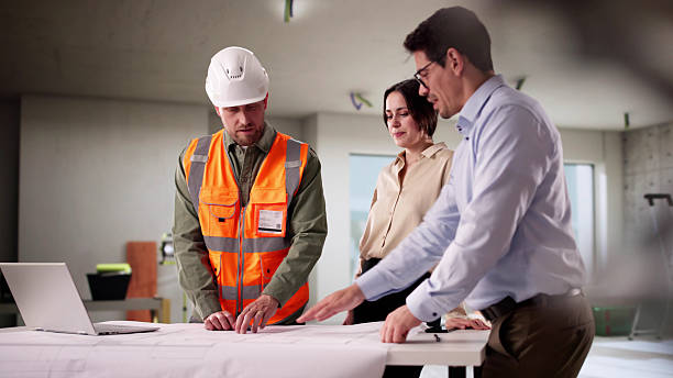 istock Professional Engineers Inspecting House Blueprint With Young Couple 2212430331