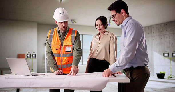 istock Engineer And Architect Inspecting Blueprint With Young Couple 2212430346