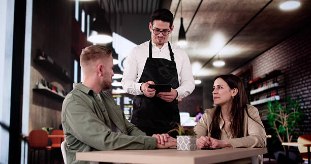 istock Romantic Waiter Taking Dinner Order From Elegant Couple 2212430427