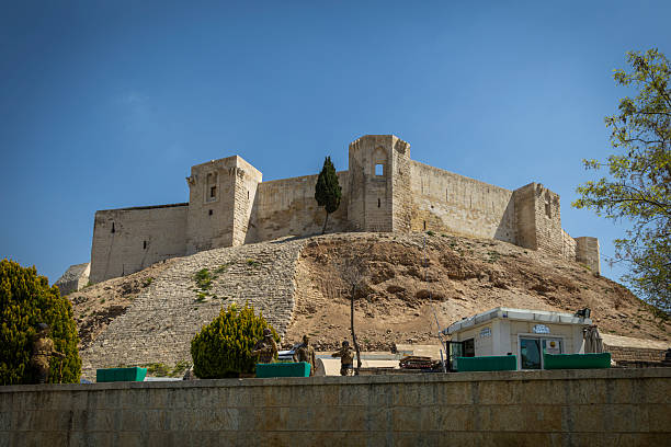 Two  Syrian women walk through a large entrance at the Citadel in Aleppo, Syria.