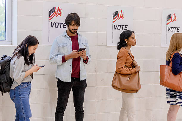 istock Diverse Group of People Waiting in Line, Using Smartphones 2212431619