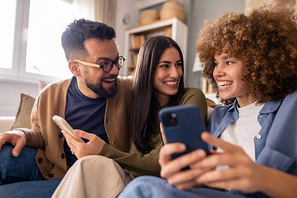 istock Three Happy Friends Chatting and Smiling on Couch During Bright Daytime Indoors 2212432901