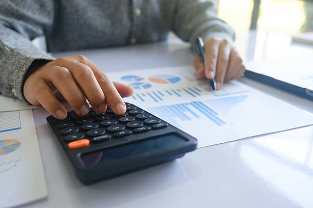 istock Close up accountant banker or bookkeeper making calculations with calculator. 2212433257