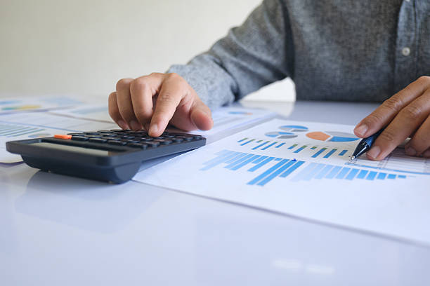 istock Close up accountant banker or bookkeeper making calculations with calculator. 2212433260