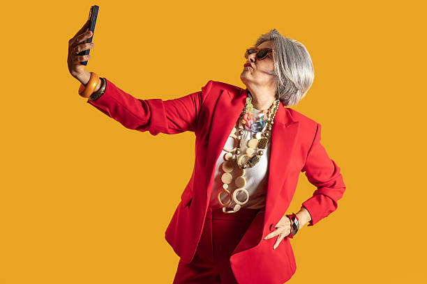 istock Senior influencer taking a selfie with mobile phone and duck face 2212434741