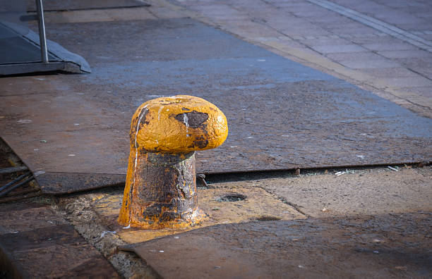 istock old, rusted, yellow bollard on a pier. 2212437543