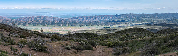 Panoramic springtime landscape view of Bear Valley from Molok Luyuk (Walker Ridge) in the Inner North Coast Ranges of Colusa County, California, with Sacramento Valley, Sutter Buttes, and the Sierra Nevada in the distance.
