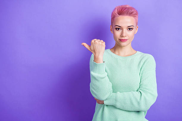 istock Photo of charming young lady direct thumb finger empty space proposition mint pullover isolated on violet color background 2212438611
