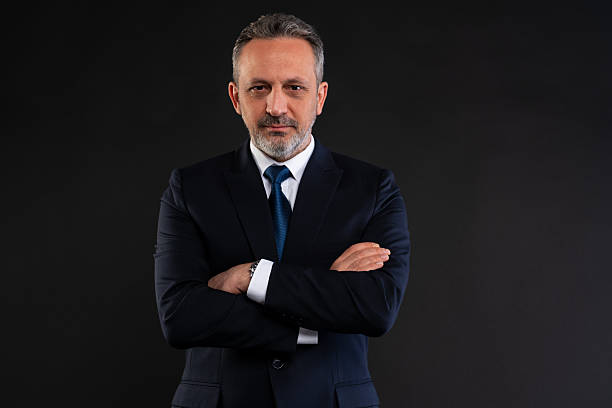 istock Confident businessman with arms crossed on black background 2212441852