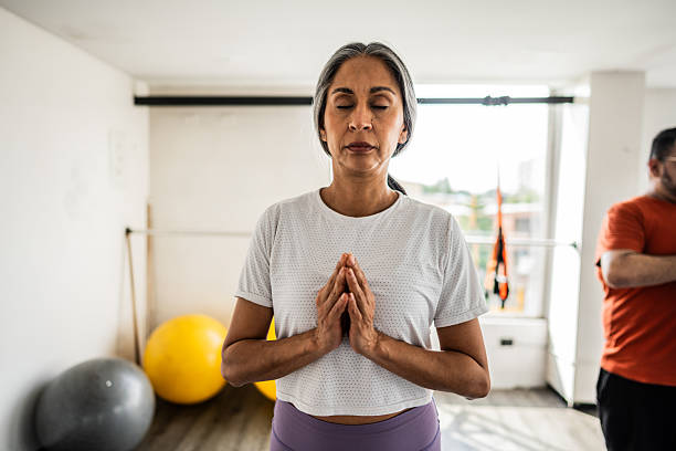 istock Mature woman doing zen exercise at gym 2212443732