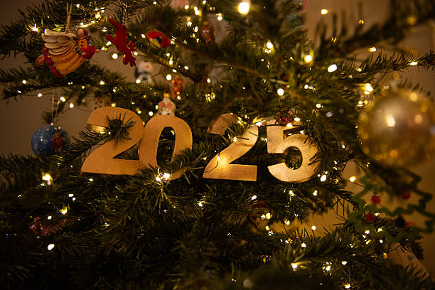 istock Horizontal Golden 2025 Ornament on Christmas Tree with Lights 2212444415