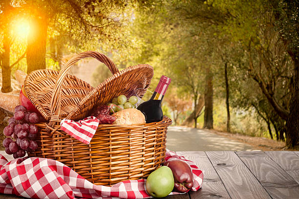istock Picnic basket on a wooden table with defocused forest trees at background 2212445170