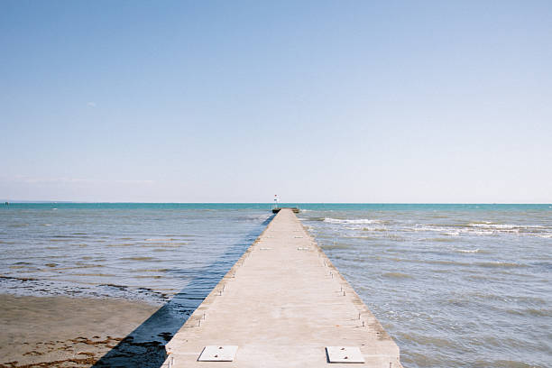The scenic view of a coastline with pier at the blue sea in sunny day