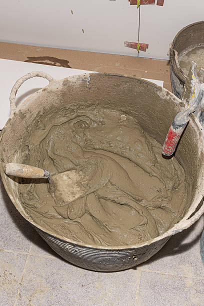 istock Mortar in a bucket with trowels, ready for a construction worker during a home renovation 2212446944