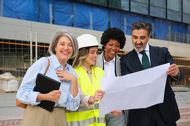 istock Multi-ethnic team of architects and engineers analyzing blueprints at construction site 2212451427