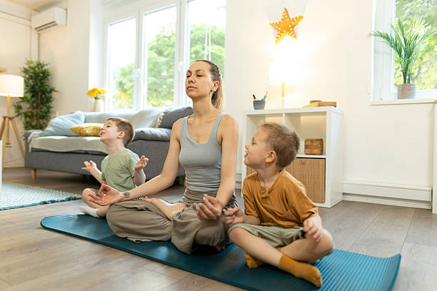 istock Mon and her toddlers in lotus pose for meditation. 2212451533