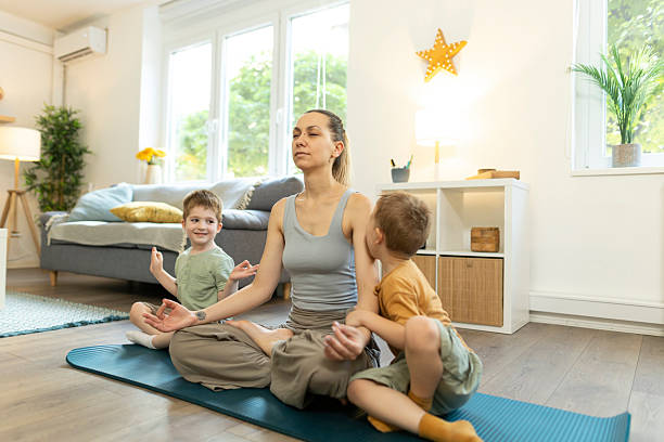 istock Mon and her toddlers in lotus pose for meditation. 2212451555