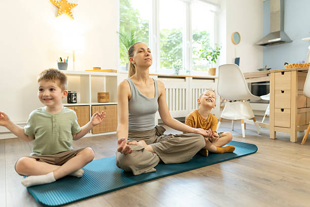 istock Mon and her toddlers in lotus pose for meditation. 2212451565