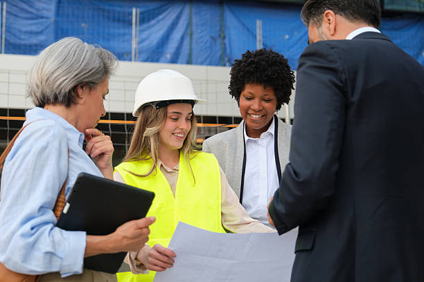 istock Diverse team of professionals examining blueprints on a construction site 2212451913