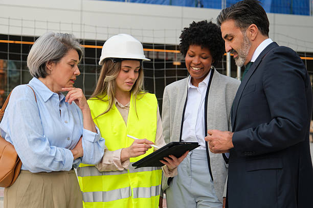 istock Architect showing building project to investors and construction engineer using tablet 2212451969