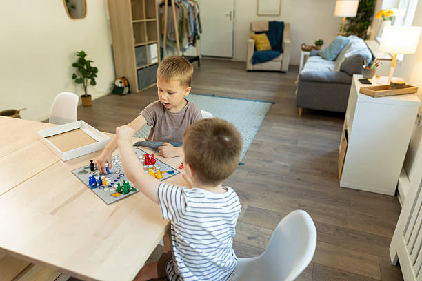 istock Toddlers plays ludo game at kitchen table 2212452074