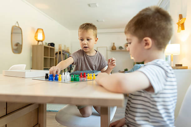 istock Two toddlers enjoy playing a ludo game together at home 2212452076