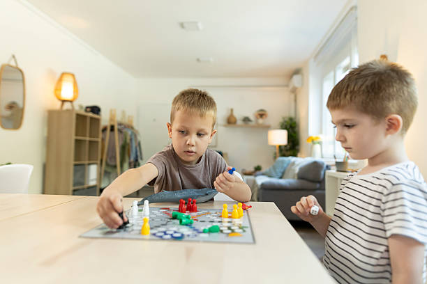 istock Two toddlers enjoy playing a ludo game together at home 2212452131