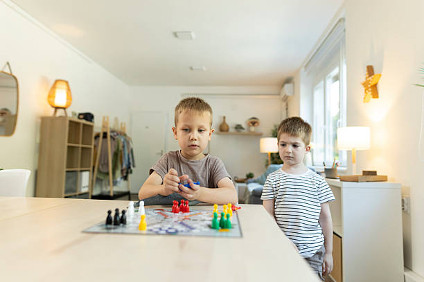 istock Toddlers plays ludo game at kitchen table 2212452134