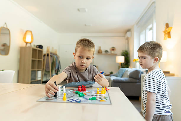 istock Toddlers plays ludo game at kitchen table 2212452136