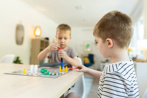 istock Siblings playing board game ludo at home 2212452143