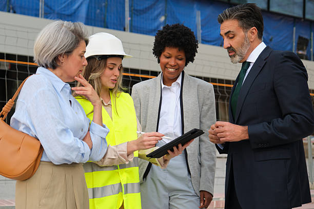 istock Architect showing building project to investors on digital tablet at construction site 2212452174