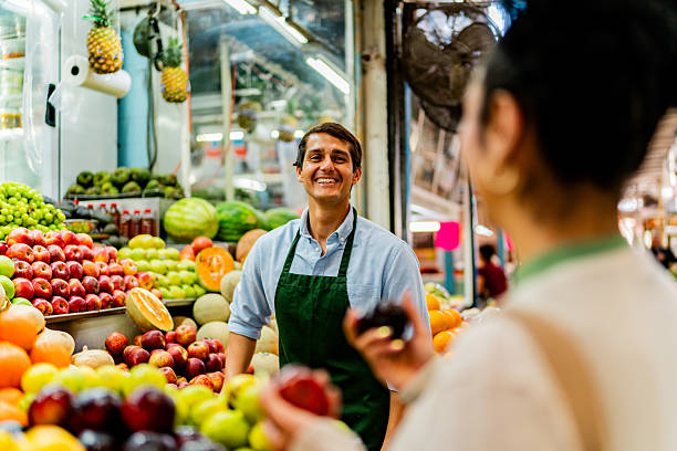 istock Young salesman talking to customer at market 2212453074