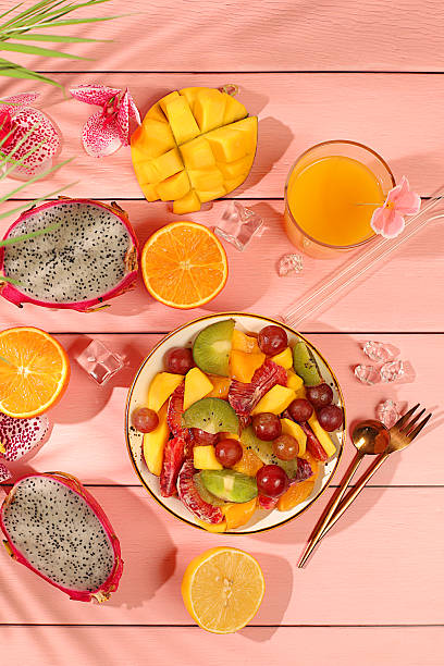 istock Fruit kitchen background with ingredients for making salad. Dragon fruit, mango, kiwi, orange, nuts and dried apricots, exotic fruits for a healthy lifestyle, advertising banner for a cafe, restaurant. 2212454175