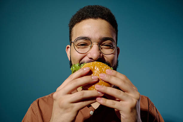 istock Portrait of Man Enjoying Delicious Burger with Joyful Expression 2212460252