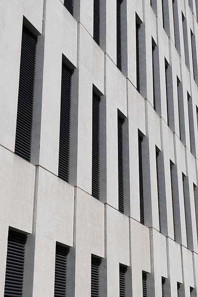 istock Modern building facade featuring vertical narrow windows set between clean, minimalist concrete panels. 2212460301