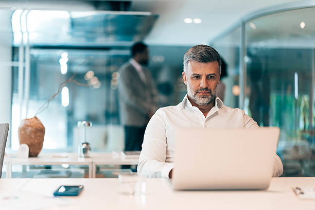 istock Focused businessman working on laptop in modern office 2212460502