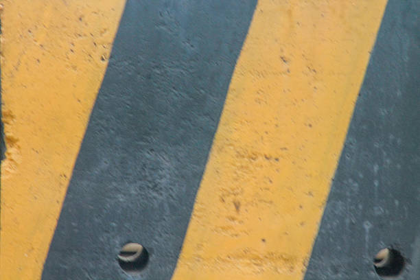 istock Temporary concrete barrier road divider in yellow and black colors. 2212460629