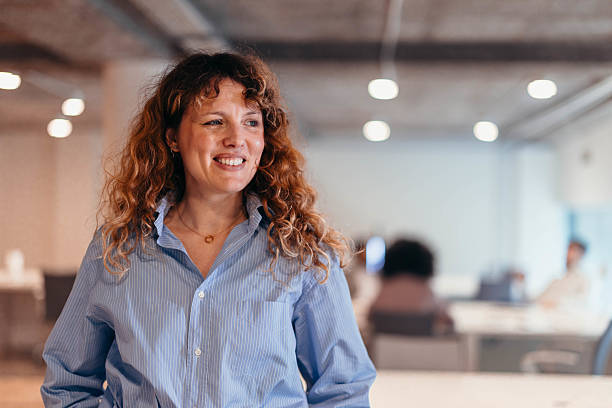 istock Confident businesswoman smiling in modern office workplace 2212460700