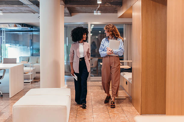 istock Two businesswomen walking and talking in modern office 2212460797