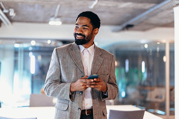 istock Smiling businessman using smartphone in modern office 2212460837