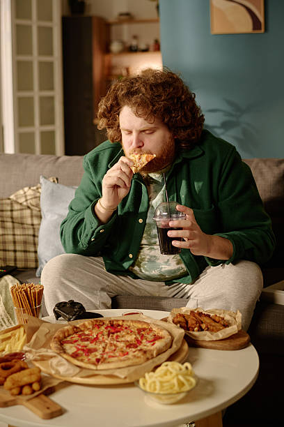 istock Enjoying Pizza and Snacks While Watching Television at Home 2212460855