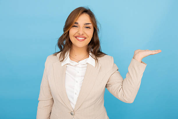 istock Businesswoman presenting and smiling on a blue background 2212461782
