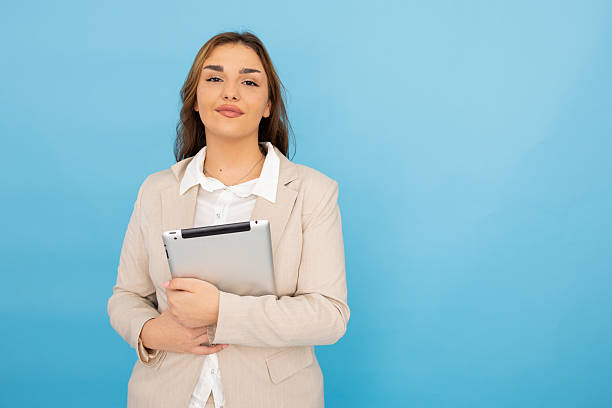 istock Confident businesswoman with digital tablet posing against blue background 2212462611