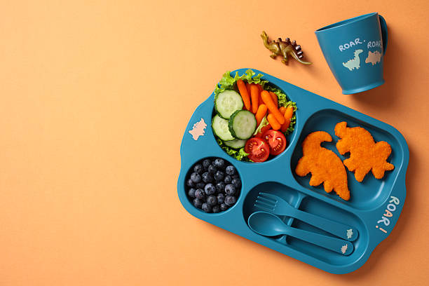 istock Fun dinosaur divided plate with healthy kid's lunch. Flat lay, top view 2212465731
