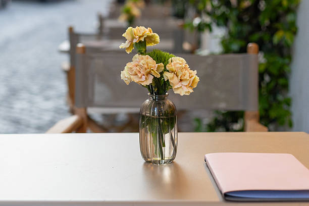 istock Elegant table setting in charming outdoor cafe with fresh flowers and a notebook 2212467505
